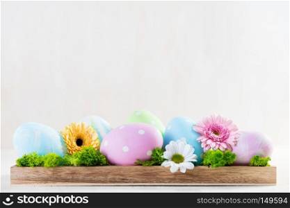 Easter decoration - eggs and flowers on a wood. White copyspace. Easter decoration - eggs and flowers on a wood