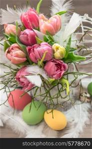 easter decoration with pink tulip flowers and colored eggs