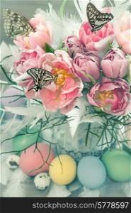 easter decoration with pink tulip flowers, butterflies and colored eggs