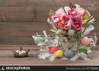 Easter decoration with pink tulips, butterflies and colored eggs