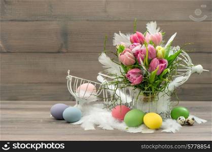 easter decoration with vintage cage, eggs and pink tulip flowers. romantic home interior. retro style colored picture