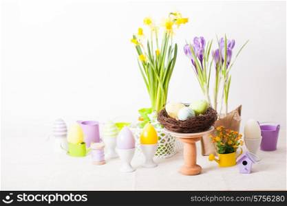 Easter decorations - egg candles, nest and flowers on the table