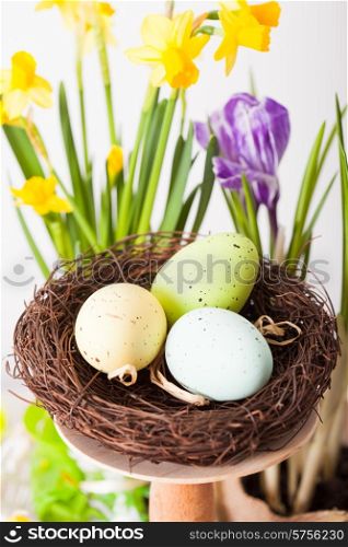 Easter decorations - egg in the nest and flowers on the table. Easter decorations