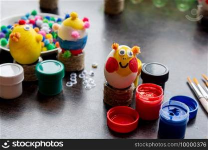Easter egg crafts, paints and decorative elements are on the table