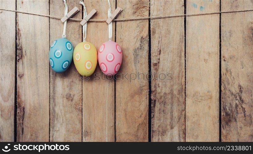easter egg hanging clothseline on wood backhround with space.