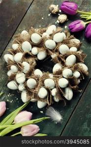 Easter egg wreath on a wooden background.