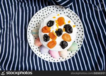 Easter eggs and Easter cake are on a plate, lying on a striped blue apron. Easter religious holiday concept. Easter eggs and Easter cake are on a plate, lying on a striped blue apron. Easter religious holiday concept.