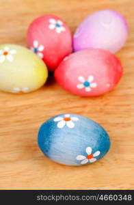 Easter eggs decorated with daisies on a wooden background