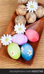 Easter eggs decorated with daisies on a wooden background