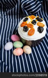 Easter eggs decorated with watercolors and Easter cake lie on a striped blue apron. Easter religious holiday concept, top view. Easter eggs decorated with watercolors and Easter cake lie on a striped blue apron. Easter religious holiday concept, top view.