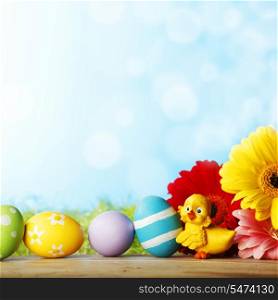 Easter eggs, flowers and chick aber green grass background