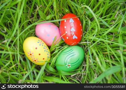 Easter eggs hunt on green grass meadow outdoor