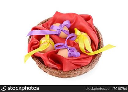 Easter eggs in a wicker basket isolated on white background.