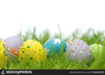 Easter eggs in fresh green grass isolated on white