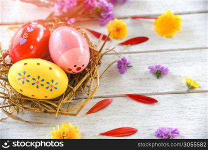 Easter eggs in nest decoration with colorful spring flowers petal on white background