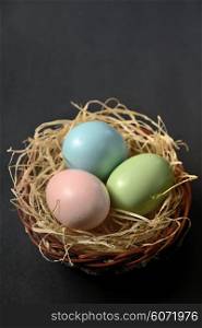 Easter eggs in the nest on black background