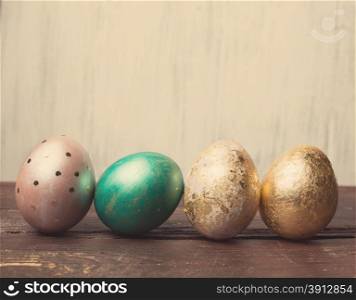 Easter eggs on rustic wooden table. Holiday background. Tinted photo.