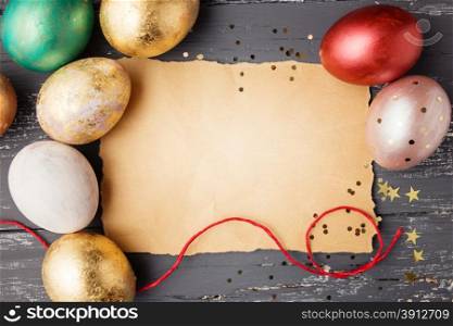 Easter eggs on wooden table with blank paper for text. Holiday background