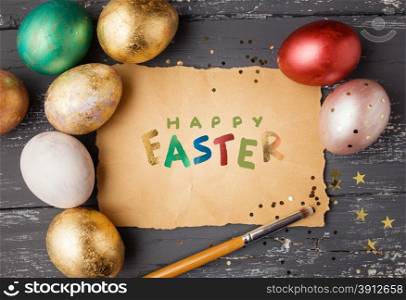 Easter eggs on wooden table with happy easter lettering. Holiday background