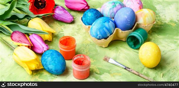 Easter Eggs, Paint and Tulips. symbolic Easter colored egg and colorful paint
