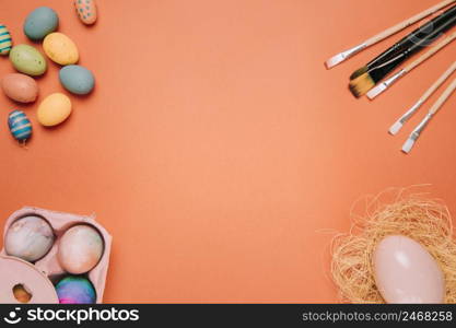 easter eggs paint brushes egg nest corner orange background