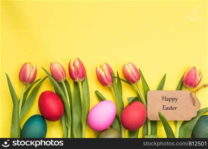 Easter eggs painted and tulips with yellow background and text happy easter april concept. Easter eggs painted and tulips with yellow background and text happy easter