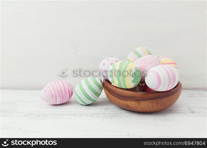 Easter eggs painted in pastel colors on white wooden background. Easter concept. Easter eggs painted in pastel colors on white wooden background. Easter concept.