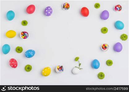 easter eggs with candies flowers scattered white table
