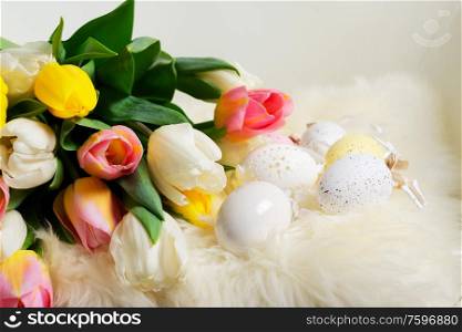 Easter eggs with fresh tulip flowers bouquet. Easter scene with colored eggs