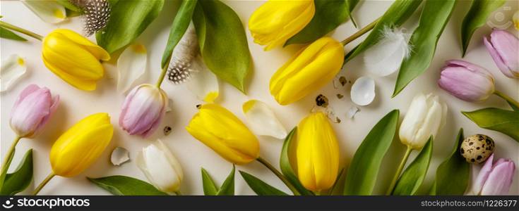 Easter floral background, spring tulips and various eggs end egg shell, flat lay, view from above