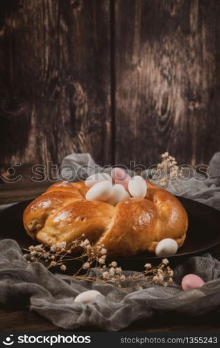 Easter folar with sugar almonds on wooden table top.