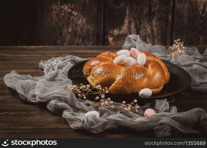 Easter folar with sugar almonds on wooden table top.