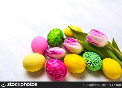 Easter green, yellow, pink painted eggs and tulips. Happy Easter greeting card or invitation, copy space