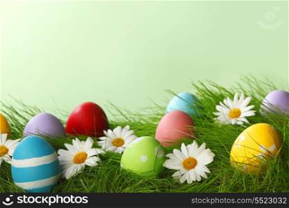Easter Greeting Card with decorated Easter eggs in the grass and flowers