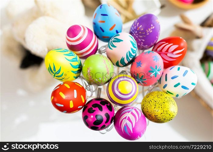 Easter holiday concept,Colorful Easter eggs in egg box,basket Easter eggs on white pastel color rustic wood background with space.
