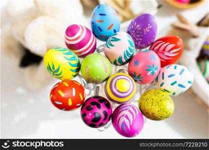 Easter holiday concept,Colorful Easter eggs in egg box,basket Easter eggs on white pastel color rustic wood background with space.
