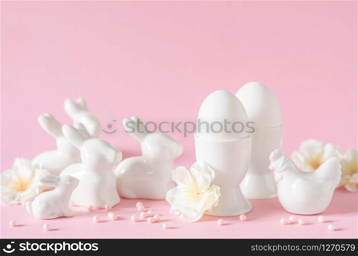 Easter holiday decorations on pink background with spring flowers, festive greeting card