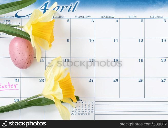 Easter holiday marked on calendar with yellow daffodils and colorful egg