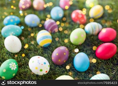 easter, holidays and tradition concept - colored eggs on artificial grass. colored easter eggs on artificial grass