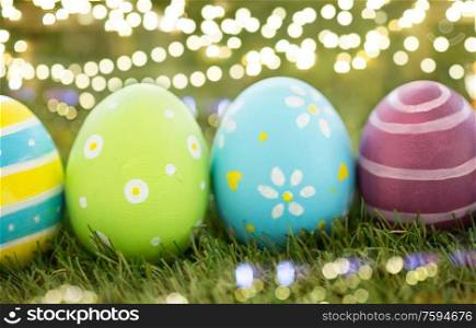 easter, holidays and tradition concept - row of colored eggs on artificial grass. row of colored easter eggs on artificial grass