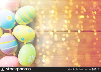easter, holidays, tradition and object concept - close up of colored easter eggs on wooden surface with copy space. close up of colored easter eggs on wooden surface