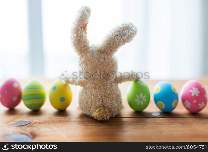 easter, holidays, tradition and object concept - close up of colored easter eggs and bunny
