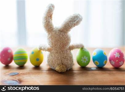 easter, holidays, tradition and object concept - close up of colored easter eggs and bunny