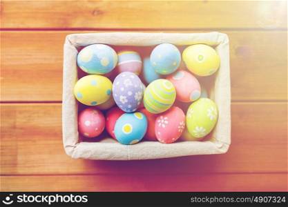 easter, holidays, tradition and object concept - close up of colored easter eggs in basket. close up of colored easter eggs in basket