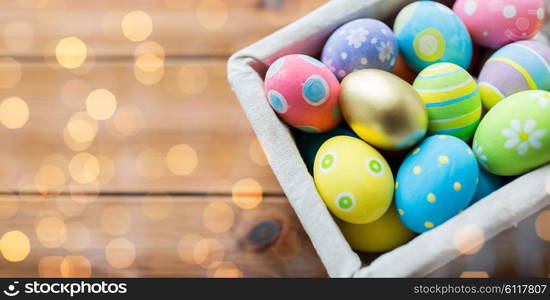 easter, holidays, tradition and object concept - close up of colored easter eggs in basket