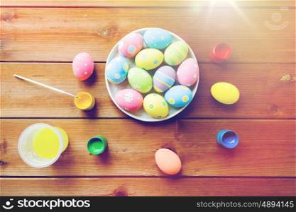 easter, holidays, tradition and object concept - close up of colored easter eggs on plate