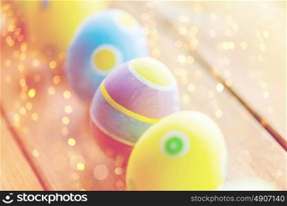 easter, holidays, tradition and object concept - close up of colored easter eggs on wooden surface. close up of colored easter eggs on wooden surface