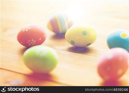 easter, holidays, tradition and object concept - close up of colored easter eggs on wooden surface. close up of colored easter eggs on wooden surface
