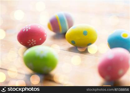 easter, holidays, tradition and object concept - close up of colored easter eggs on wooden surface