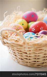 easter, holidays, tradition and object concept - close up of colored eggs in basket. close up of colored easter eggs in basket